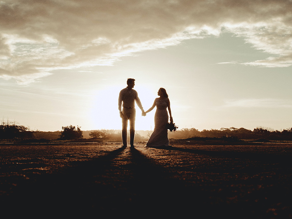 Silhouette of a groom and a bride holding hands (Unsplash/Jonathan Borba)