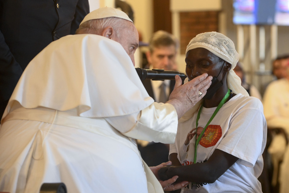 Pope Francis caresses the cheek of a woman whose hand was amputated in the violence that continues to plague the eastern part of Congo. The pope met victims of violence Feb. 1 at the apostolic nunciature in Kinshasa. (CNS/Vatican Media)