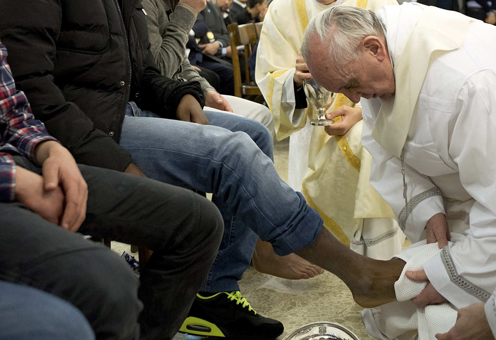 Pope Francis washes the foot of a prison inmate during the Holy Thursday Mass of the Lord's Supper at Rome's Casal del Marmo prison for minors March 28, 2013. Pope Francis washed the feet of 12 young people of different nationalities and faiths, including at least two Muslims and two women, who are housed at the juvenile detention facility. (CNS/L'Osservatore Romano via Reuters)