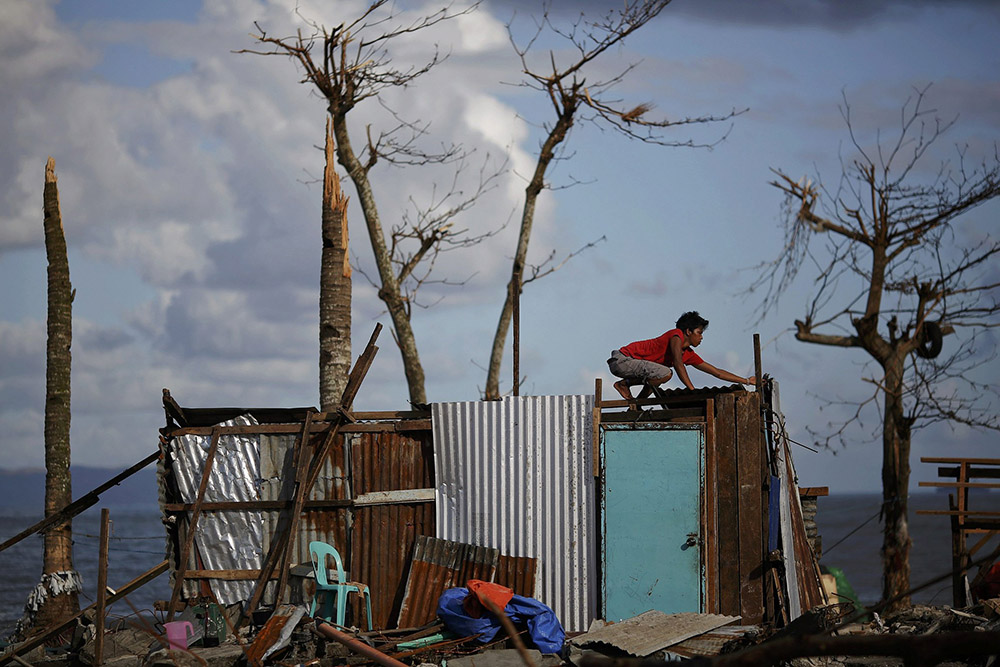 A man repairs his house, which was damaged by Super Typhoon Haiyan, at a coastal area south of Tacloban, the Philippines, Nov. 16, 2013. (CNS/Reuters/Damir Sagolj)
