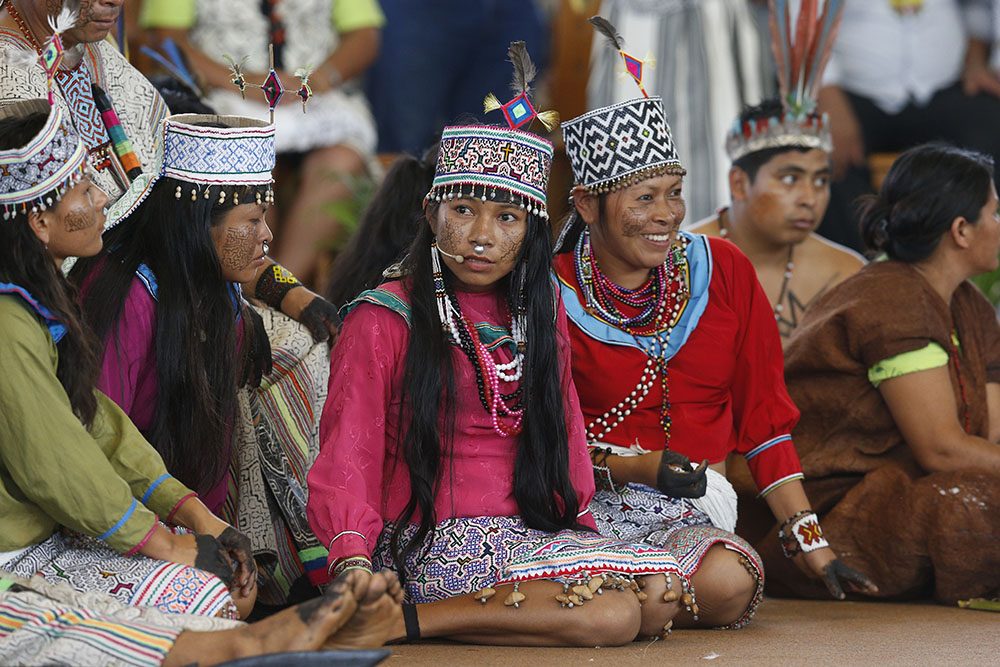 Young members of an Indigenous group from the Amazon region listen during a meeting with Pope Francis Jan. 19, 2018, at Madre de Dios stadium in Puerto Maldonado, Peru. (CNS/Paul Haring)