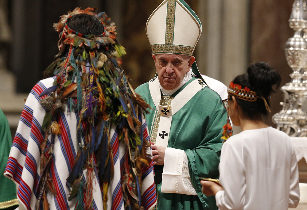 Pope Francis accepts offertory gifts from Indigenous people at the concluding Mass of the Synod of Bishops for the Amazon at the Vatican in this Oct. 27, 2019, file photo. The Vatican on Feb. 12, 2020, released the pope's apostolic exhortation, Querida Amazonia ("Beloved Amazonia"), which offers his conclusions from the synod. (CNS/Paul Haring)