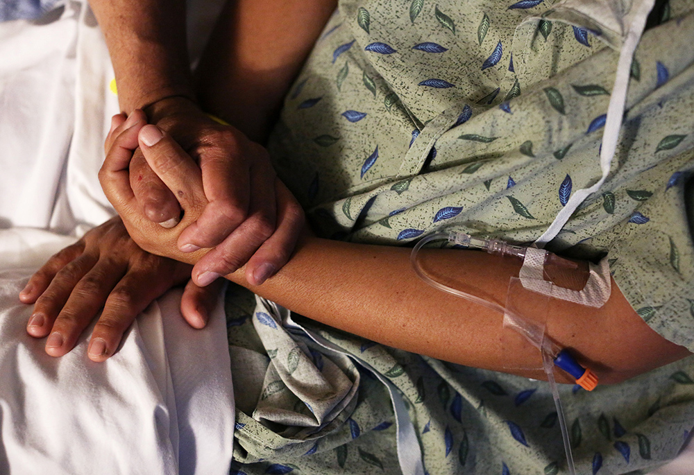 Un miembro de la familia consuela a un paciente del hospital en esta foto ilustrativa. Los obispos católicos de EE. UU. emitieron un documento fechado el 20 de marzo rechazando los tratamientos médicos de afirmación de género para personas transgénero y reafirmando que dichos procedimientos no deben ser realizados por proveedores católicos. (CNS/Reuters/Caitlin O'Hara)