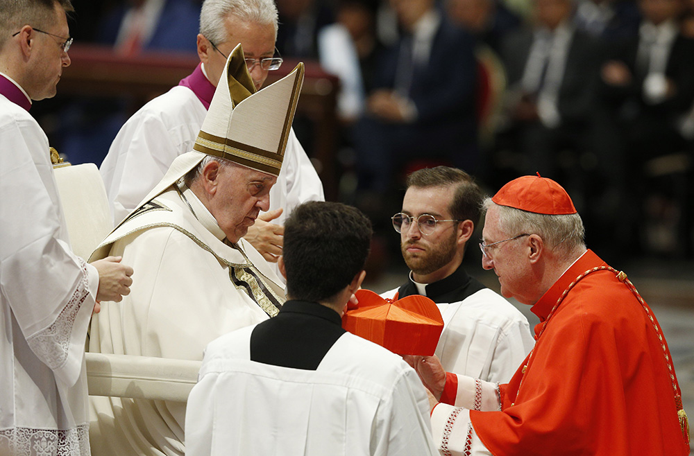 Pope Francis prepares to place the red biretta on new English Cardinal Arthur Roche, prefect of the Dicastery for Divine Worship and the Sacraments, during a consistory for the creation of 20 new cardinals in St. Peter's Basilica at the Vatican Aug. 27, 2022. (CNS photo/Paul Haring)