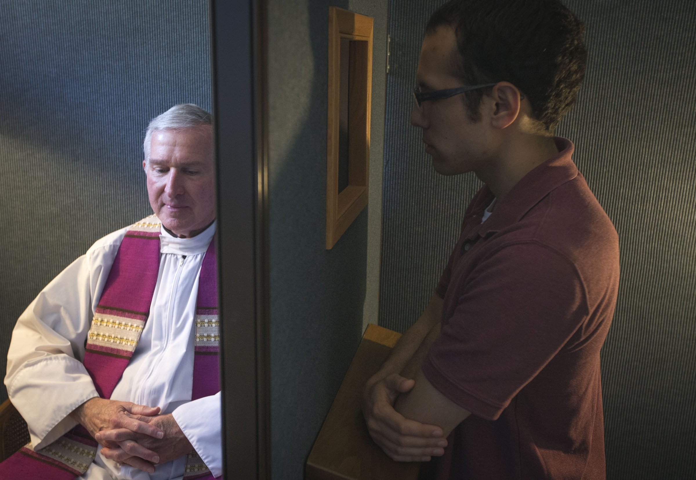 Fr. Timothy J. Mockaitis, pastor of Queen of Peace Church in Salem, Oregon, and penitent Ethan K. Alano of Salem demonstrate how a confession is conducted in this May 3, 2019, photo. (OSV News photo/CNS file, Chaz Muth)