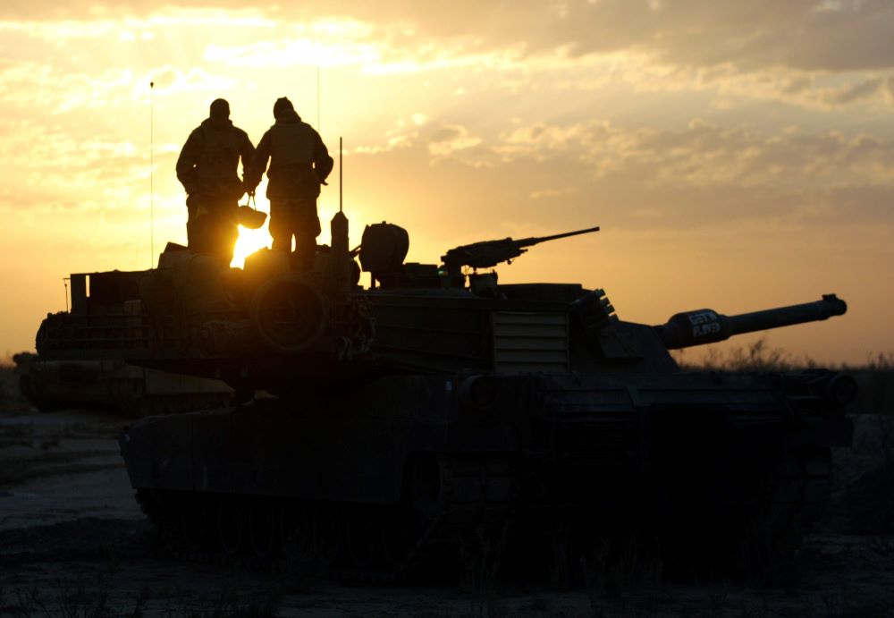 Soldiers standing on tanks are silhouetted against  Tank crew members of the U.S. Marines 3rd Battalion, 4th Regiment, are silhouetted at sunrise near Baghdad, Iraq.