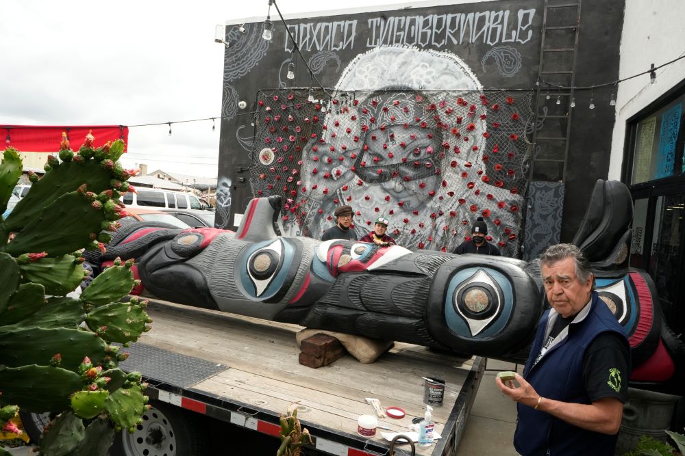 Wood carver Douglas James, 71, a member of the Lummi Nation who traveled from Washington State, retouches the paint of a totem pole touring across the country in an attempt to stop the degradation of Native lands, as he joins members of the Apache Stronghold group gathered at Self Help Graphics & Art in the Los Angeles neighborhood of Boyle Heights in Los Angeles Monday, March 20, 2023.