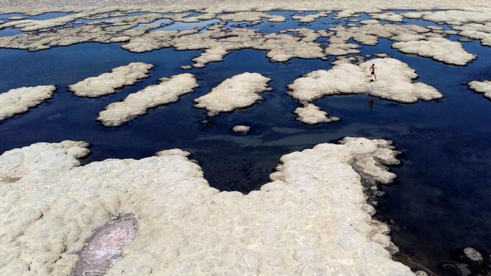 Olof Wood walks across reef-like structures called microbialites, exposed by receding waters at the Great Salt Lake, Tuesday, Sept. 6, 2022, near Salt Lake City.