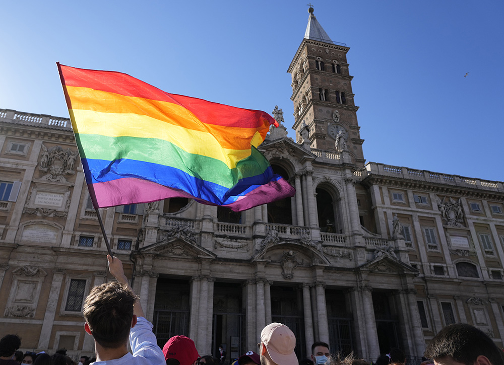 A demonstrator waves a rainbow flag in front of the Basilica of St. Mary Major during the annual Pride march in Rome June 26, 2021. (AP/Gregorio Borgia)
