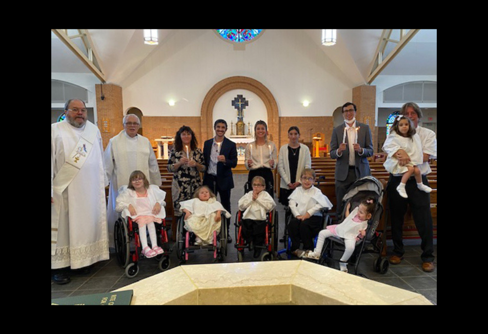The Greenan family is pictured on the day of the baptism of their adopted children from Ukraine, at St. John Vianney in Prince Frederick, Maryland. Pictured in the front row, left to right, are: Dasha, Tatiana, Sawyer, Anthony and Cabrini. In the back row, left to right, are Deacon Jim Caldwell; Fr. Peter Daly; Vicki, Michael, Carolyn and Alex Greenan; Brandon Szalinski (Carolyn's fiance); and Ed Greenan, holding Anya. (Courtesy of the Greenan family)