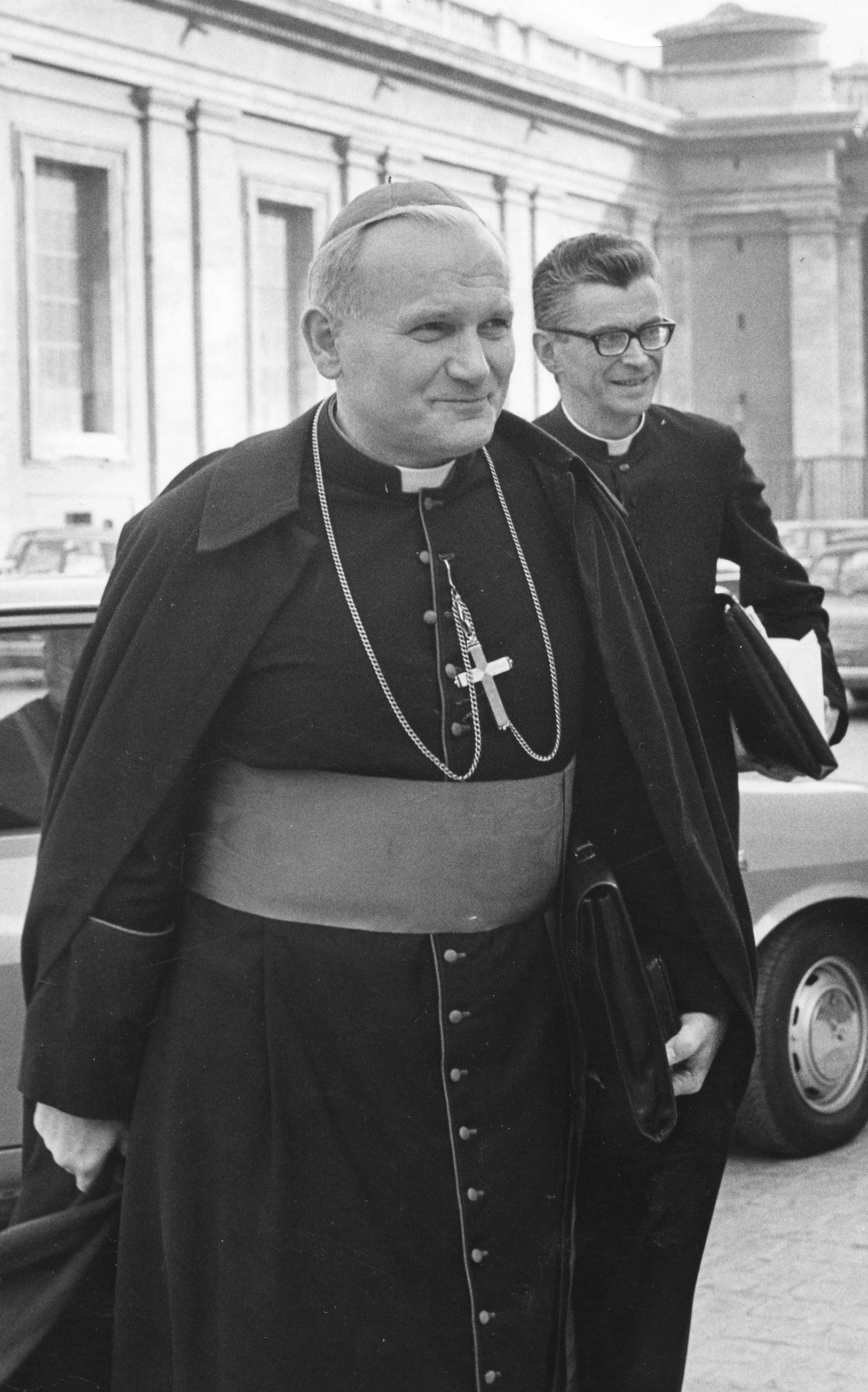 Black and white photo of Cardinal Karol Wojtyla (who later became Pope John Paul II) with a priest in the background
