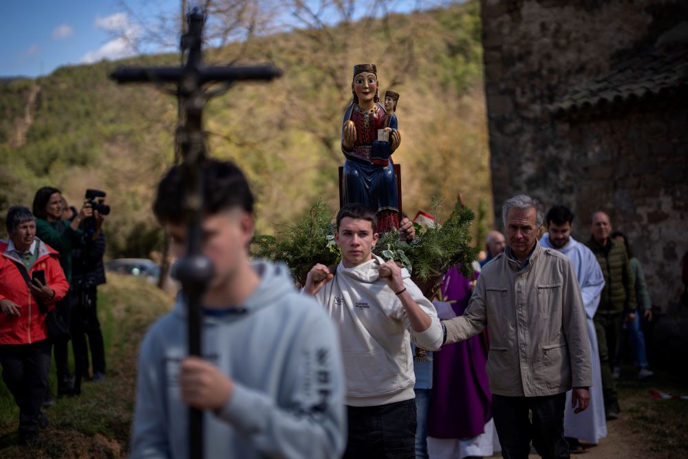 Local residents take part in a procession carrying a statue of the Our Lady of the Torrents, a virgin historically associated with drought, in l'Espunyola, north of Barcelona, Spain, Sunday, March 26, 2023. (AP Photo/Emilio Morenatti)