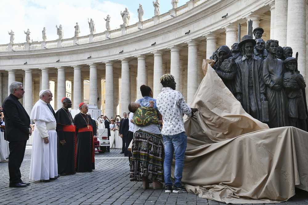 Pope Francis, left, watches the unveiling of the new sculpture "Angels Unawares" on the occasion of the Migrant and Refugee World Day, in St. Peter’s Square, at the Vatican, on Sept. 29, 2019. (Vincenzo Pinto/Pool Photo via AP)