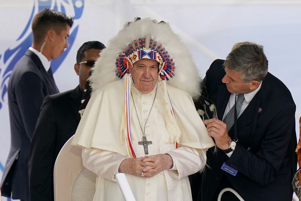 Pope Francis dons a headdress that was gifted to him during a visit with Indigenous peoples at Maskwaci, the former Ermineskin Residential School, Monday, July 25, 2022, in Maskwacis, Alberta. (AP Photo/Eric Gay)