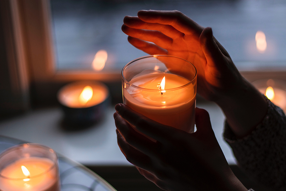Hands holding a candle (Unsplash/Rebecca Peterson Hall)