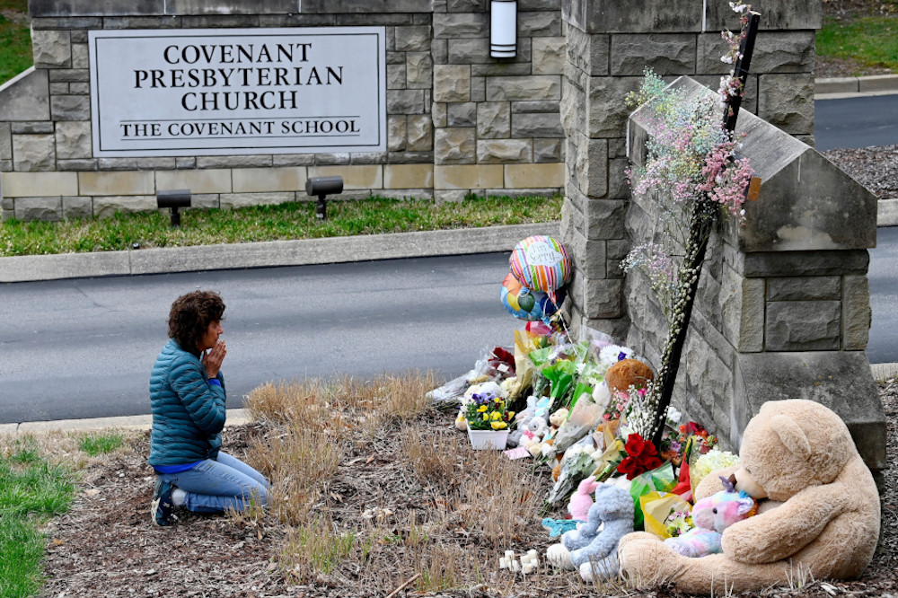 A woman prays in front of a makeshift memorial in Nashville, Tennessee, March 28, by the entrance of the Covenant School the day after a mass shooting. Three adults and three children, all 9 years old, were fatally shot at the school. (OSV News/USA Today Network via Reuters/Mark Zaleski)