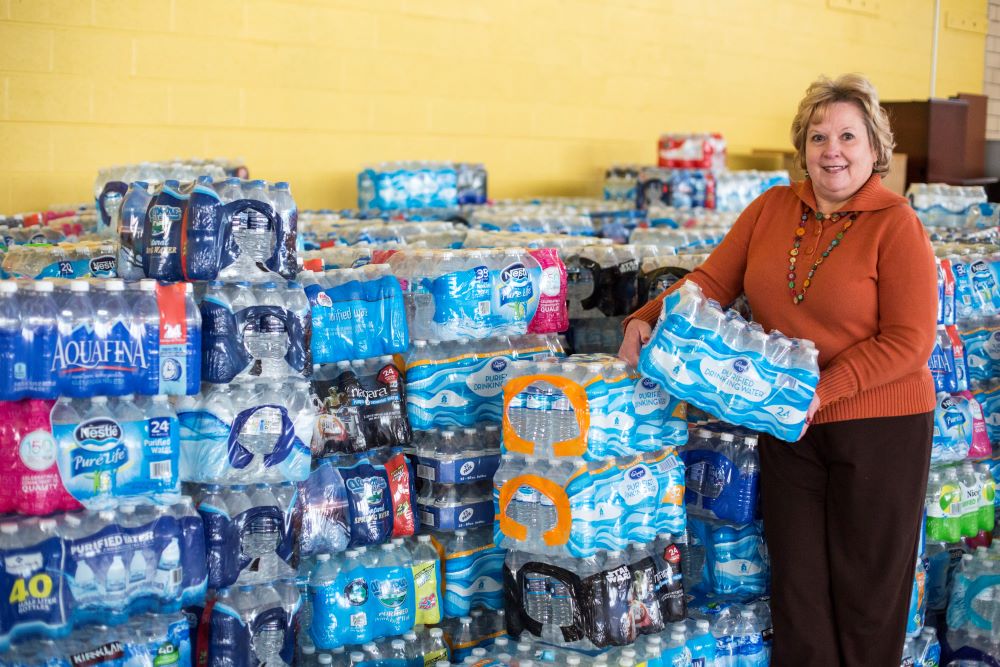 Vicky Schultz, president and CEO of Catholic Charities of Shiawassee and Genessee counties in Flint, Mich., displays some of the bottled water Jan. 19 that has been donated to help Flint residents whose water has been contaminated with lead. Michigan Gov. Rick Snyder said he has failed Flint residents but pledged to take new steps to fix the city's drinking water crisis, starting with committing millions in state funding. (CNS/Jim West)