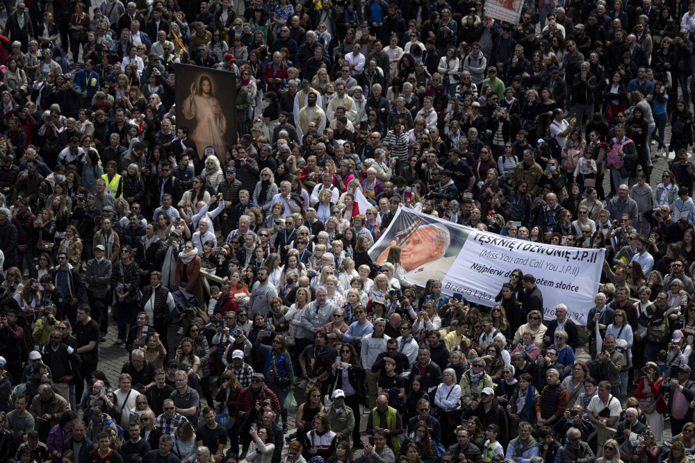 Pilgrims holding an image of Divine Mercy and others holding a banner featuring St. John Paul II, who instituted the universal celebration of Divine Mercy Sunday, join Pope Francis for the recitation of the "Regina Coeli" prayer April 16, 2023, in St. Peter's Square at the Vatican. (CNS photo/Vatican Media)