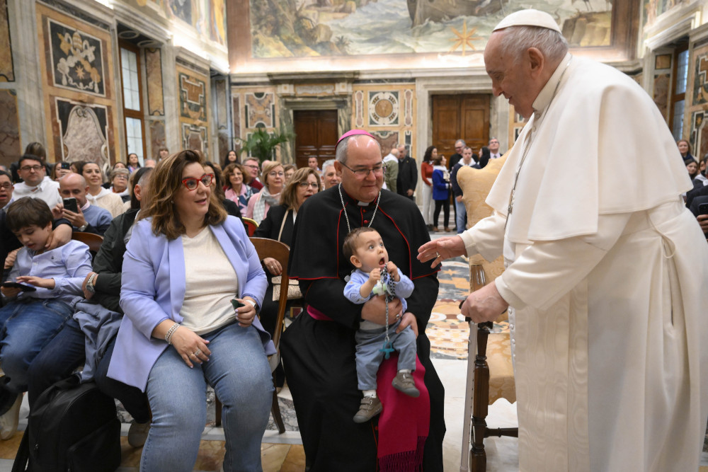 Pope Francis greets a child and Archbishop Francisco Cerro Chaves of Toeldo, Spain, during an audience with the archdiocese's Mother of Hope of Talavera de la Reina Foundation at the Vatican April 15, 2023. (CNS photo/Vatican Media)