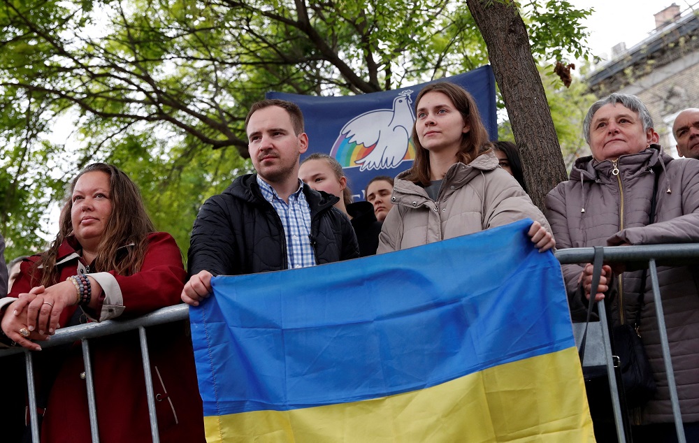 Ukrainians hold the Ukrainian flag at the Church of Saint Elizabeth of Hungary as Pope Francis meets with the poor and with refugees during his apostolic journey in Budapest, Hungary, April 29, 2023. 