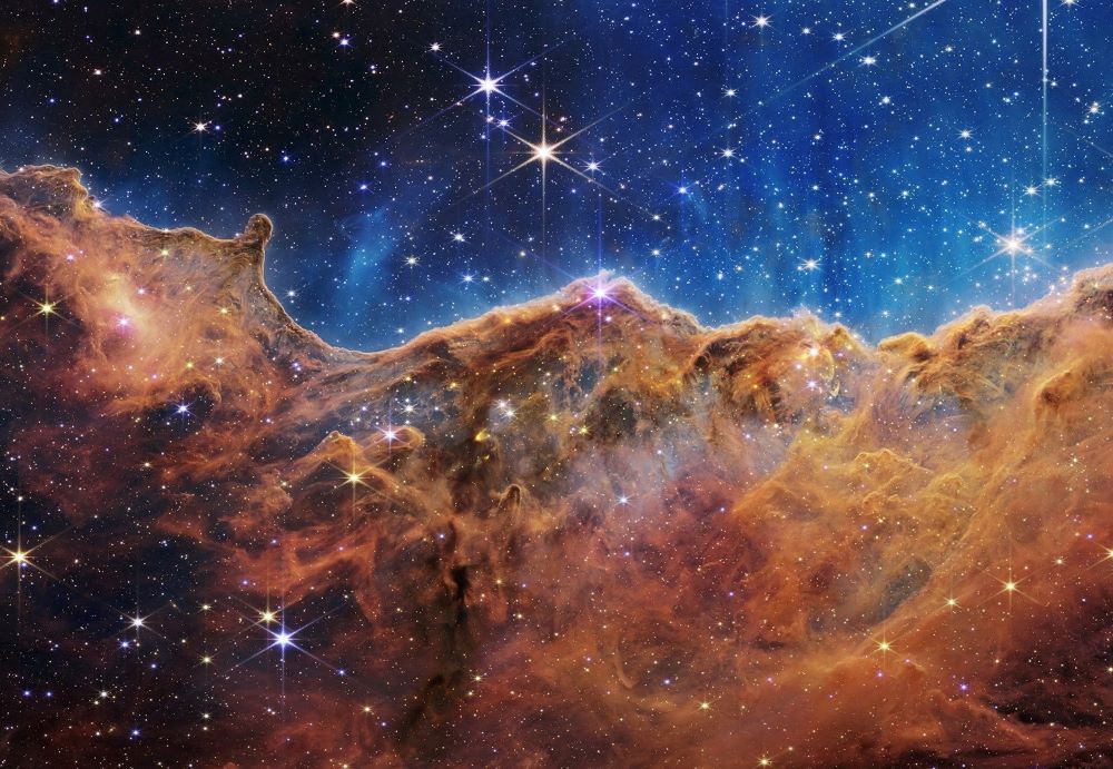 The "Cosmic Cliffs" of the Carina Nebula are seen in an image released by NASA July 12, 2022. The "cliffs" are divided horizontally by an undulating line between a cloudscape forming a nebula along the bottom portion and a comparatively clear upper portion. The image is from data provided by NASA's James Webb Space Telescope. (OSV News/NASA, ESA, CSA, STScI, Webb ERO Production Team, Handout via Reuters)
