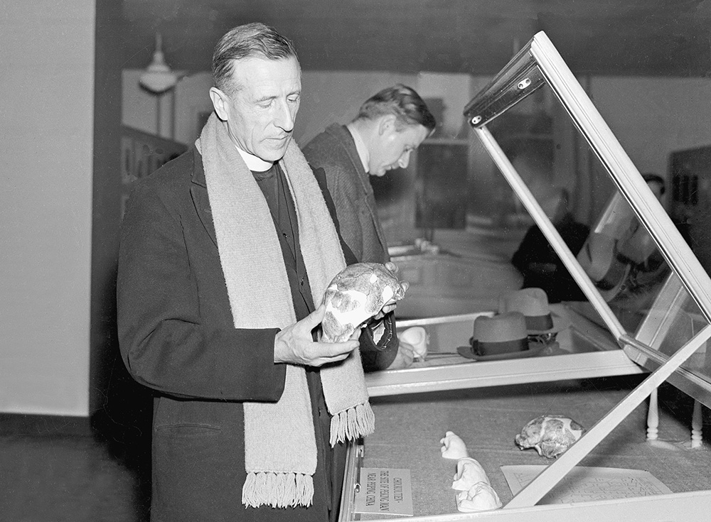 Jesuit Fr. Pierre Teilhard de Chardin, at the Symposium on Early Man at the Academy of Natural Sciences in Philadelphia on March 18, 1937, holds the skull of a Peking man he found in Beijing. (AP Photo)
