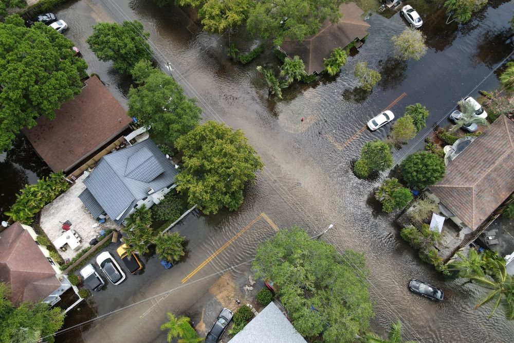 A pair of waterlogged cars sit abandoned in the road as floodwaters recede in the Sailboat Bend neighborhood of Fort Lauderdale, Fla., Thursday, April 13, 2023. Over 25 inches of rain fell in South Florida since Monday, causing widespread flooding. (AP Photo/Rebecca Blackwell)