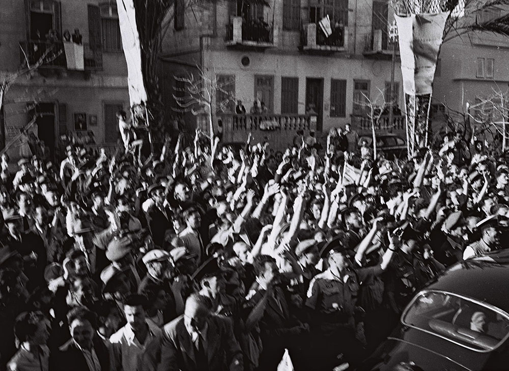 Citizens outside cheer during the ceremony to sign Israel's declaration of independence on May 14, 1948, in Tel Aviv. (Wikimedia Commons/Israel Government Press Office/Hans Pinn)