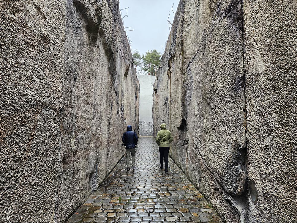Visitors to the Bełżec death camp memorial in Poland approach it through a narrow 200-yard path, walking toward the area where the gas chambers stood, trapped on both sides by steep inclines. (NCR photo/Chris Herlinger)