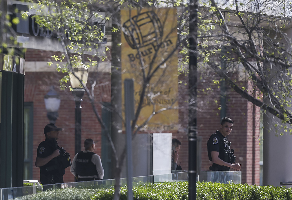 Louisville Metro Police stand guard outside the Old National Bank in Louisville, Kentucky, on Monday morning, April 10, after a shooting. Police say a 23-year-old armed with a rifle opened fire at his Louisville workplace, killing and wounding several, and was killed by police responding to the shooting. (Matt Stone/Courier Journal via AP)