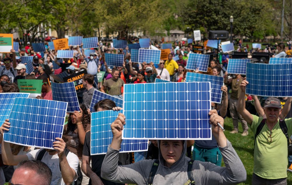Activists display prints replicating solar panels during a rally to mark Earth Day at Lafayette Square, Washington, April 23, 2022. (AP/Gemunu Amarasinghe)