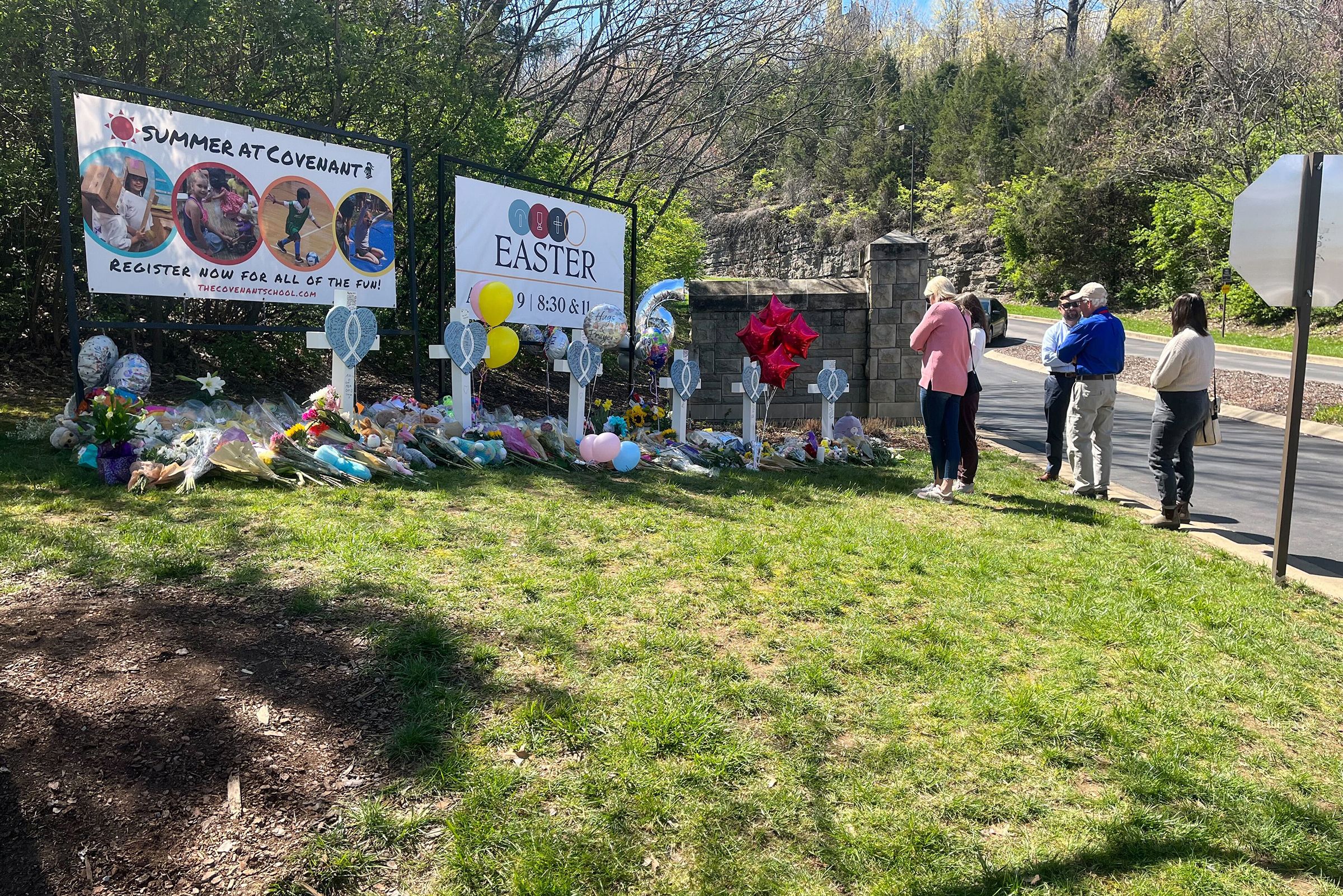 People pay respects at a memorial for the six people who were killed by a shooter, at an entry to The Covenant School in Nashville, Tennessee