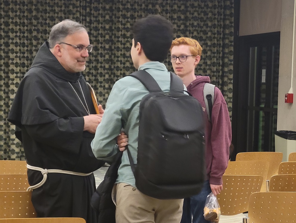 Bishop John Stowe of Lexington, Kentucky talks with students from Loyola University Chicago after the bishop's talk on "The Common Good and Synodality: The Vision of Pope Francis" April 11. (NCR photo/Heidi Schlumpf)