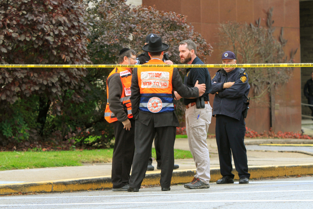Police officers are seen speaking with Jewish men after a gunman killed at least eleven people Oct. 27, 2018, at the Tree of Life Synagogue in Pittsburgh. Robert Bowers opened fire that morning during a service at the synagogue, also wounding at least six others, including four police officers, authorities said. (CNS/Reuters/John Altdorfer)
