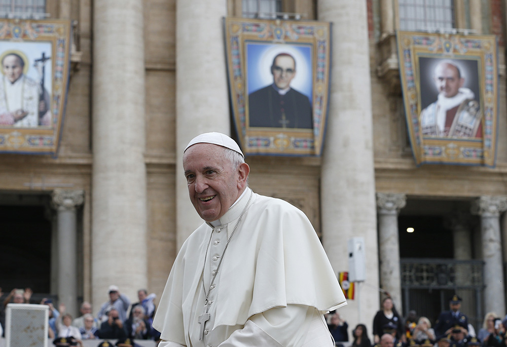 Pope Francis passes banners of newly canonized saints during his general audience in St. Peter's Square Oct. 17, 2018, at the Vatican. The banners show Sts. Vincenzo Romano, Oscar Romero and Paul VI. (CNS/Paul Haring)