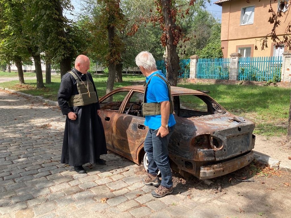 Auxiliary Bishop Jan Sobilo of Kharkiv-Zaporizhia, Ukraine, looks at a destroyed vehicle in in the summer of 2022 in the eastern Ukrainian region covered by the diocese.