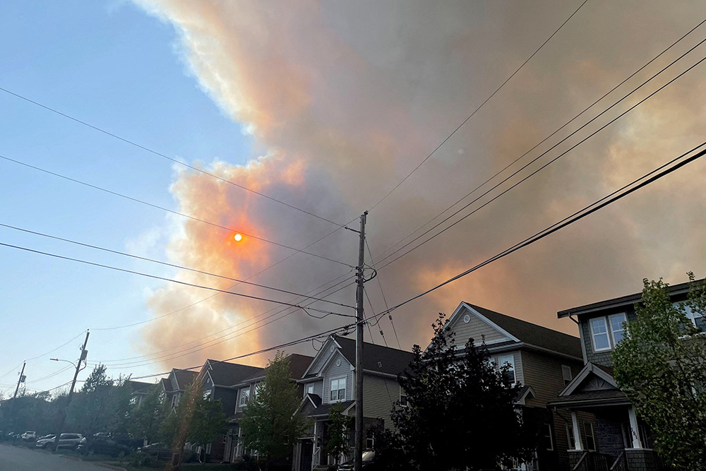 Smoke from the Tantallon wildfire rises over houses in Bedford, Nova Scotia, May 28. (OSV News/Reuters/Eric Martyn)