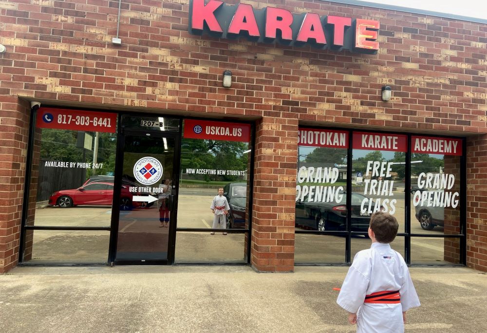 The author's son stands in front of the dojo that has become a haven of love and belonging — a sacred space — for their family. (Courtesy of Britt Luby)
