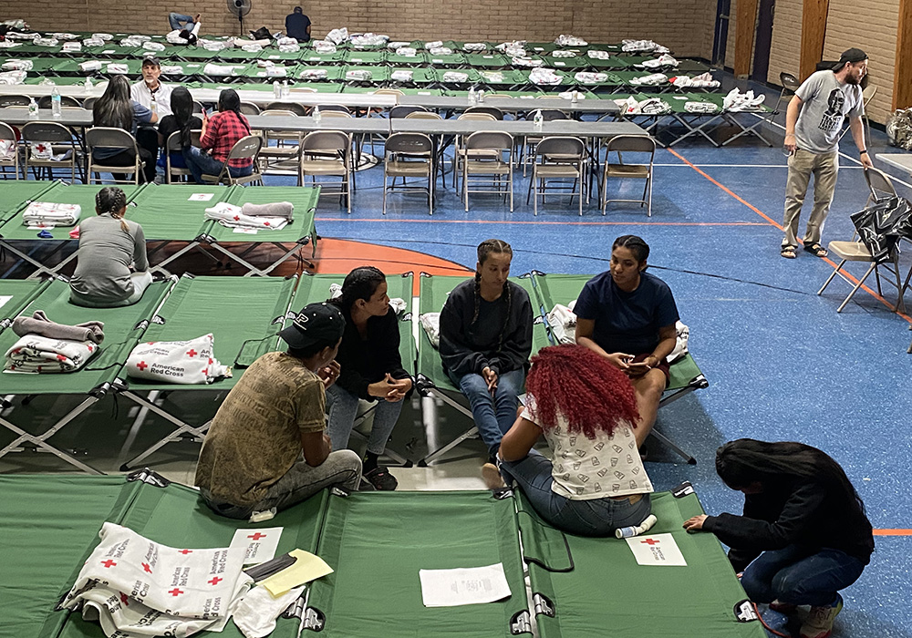 Migrants rest and plan their trip ahead May 13 at a temporary shelter the Diocese of El Paso set up at Our Lady of Assumption Parish in El Paso, Texas. The diocese has been working with local governments and organizations to prepare for an influx of migrants in the border city. (NCR photo/Rhina Guidos)