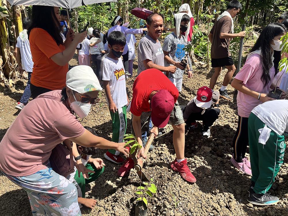 Teens help plan tree saplings in Sitio Bakal, a field outside Quezon City, Philippines, as part of a local Run4Unity event. (Fralynn Ibanez Manalo)