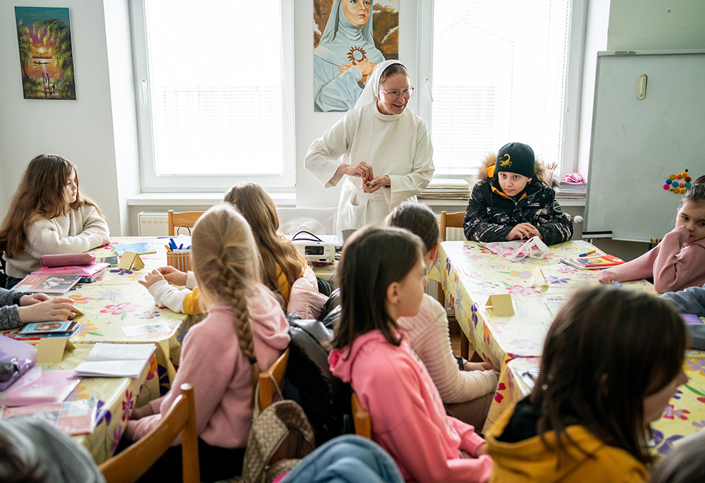 Sr. Lydia Timkova of the Dominican Sisters of Blessed Imelda teaches a catechism class in Mukachevo, Ukraine, in February. Timkova has made four cross-country missions to deliver humanitarian aid to areas in eastern Ukraine most affected by the war. Though that work is important to her, she says her primary calling remains as a teacher to her students. who include new arrivals from other parts of Ukraine displaced during the war. (Gregg Brekke)