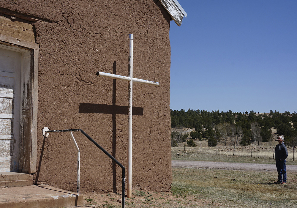 Frank Graziano stands in front of the 1840s San Geronimo Church April 15 in the mountain valley hamlet, west of Las Vegas, New Mexico. Graziano's nonprofit, Nuevo Mexico Profundo, is hoping to conserve the historic adobe church that's now in danger of collapsing, as are many remote chapels in this rural area with dwindling congregations and chronic poverty. (AP photo/Giovanna Dell'Orto)