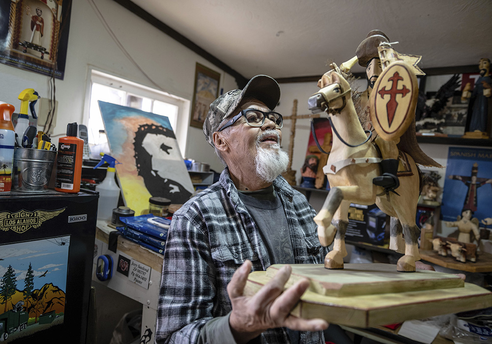 Santero Jerry Sandoval holds one of his bultos depicting St. James, in his studio April 14 in Cordova, New Mexico. Sandoval says a prayer to each saint before starting to sculpt their image out of pine, cottonwood or aspen. (AP photo/Roberto E. Rosales)