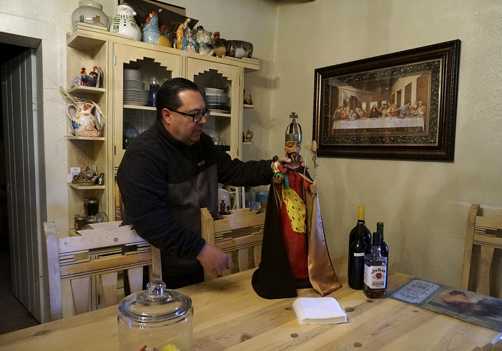 Mayordomo Fidel Trujillo shows a bulto, or wooden sculpture, of St. Joseph, that's kept for safekeeping at his aunt's home April 15 in Ledoux, New Mexico. Each mission church is devoted to a particular saint, for whom the community develops such veneration that the image is sometimes kept at the home of mayordomos for safekeeping and easier access. (AP photo/Giovanna Dell'Orto)