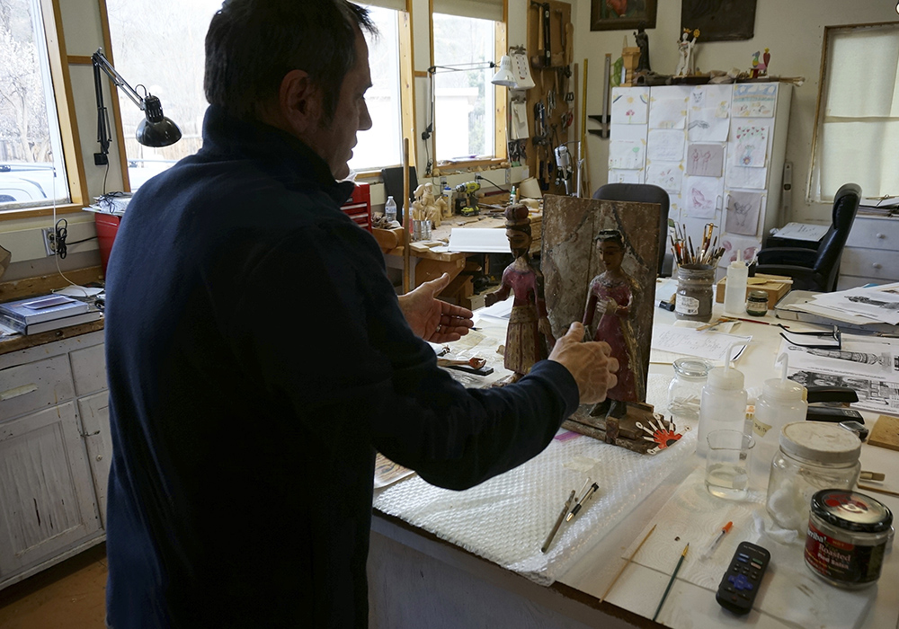 Victor Goler adjusts a holy family sculpture or bulto in his studio April 14 outside Taos, New Mexico. As a conservator and master santero — an artist trained in New Mexico's centuries-old tradition of religious sculpture and painting — Goler has worked on many historic and imperiled churches, helping to conserve their distinctive artistic patrimony. (AP photo/Giovanna Dell'Orto)