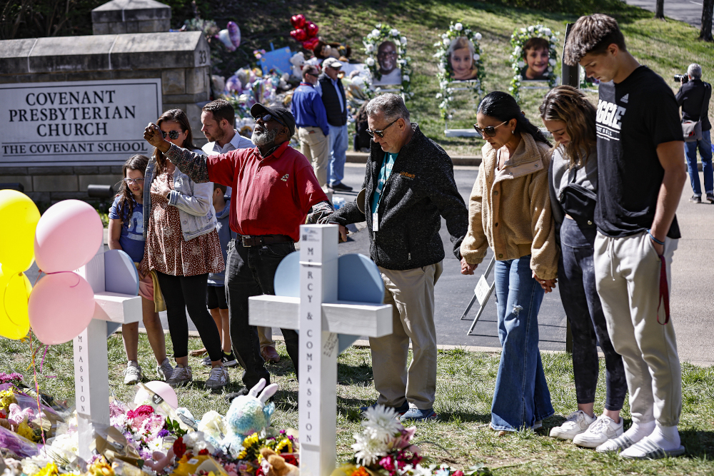 Fitzgerald Moore leads a group in prayer at a memorial for victims in a recent mass shooting at an entrance to The Covenant School on March 29, in Nashville, Tennessee. (AP/Wade Payne)