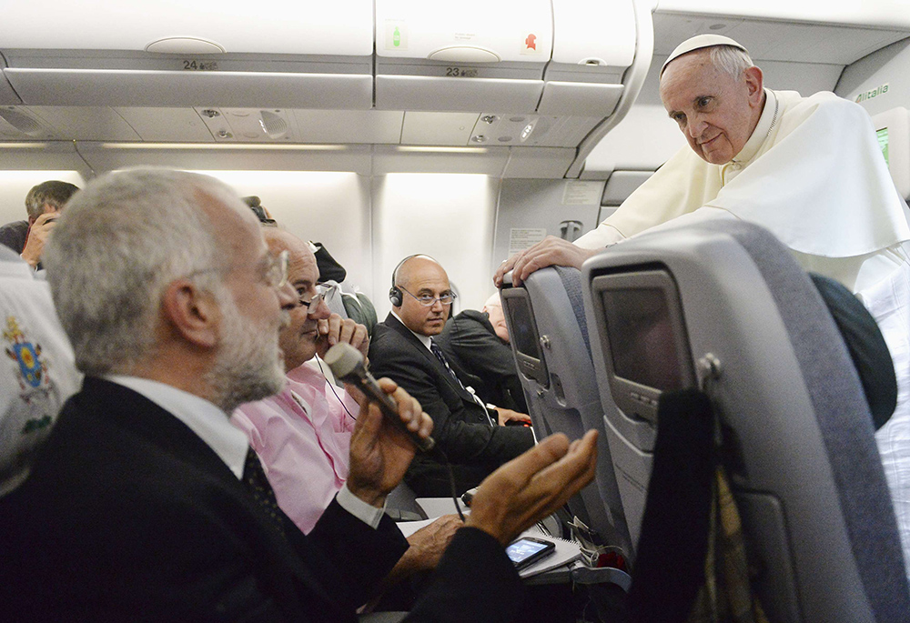 Pope Francis listens to a question from a journalist on his flight heading back to Rome July 28, 2013. The pope answered questions from 21 journalists over a period of 80 minutes on his return from Brazil. (CNS/pool via Reuters) 