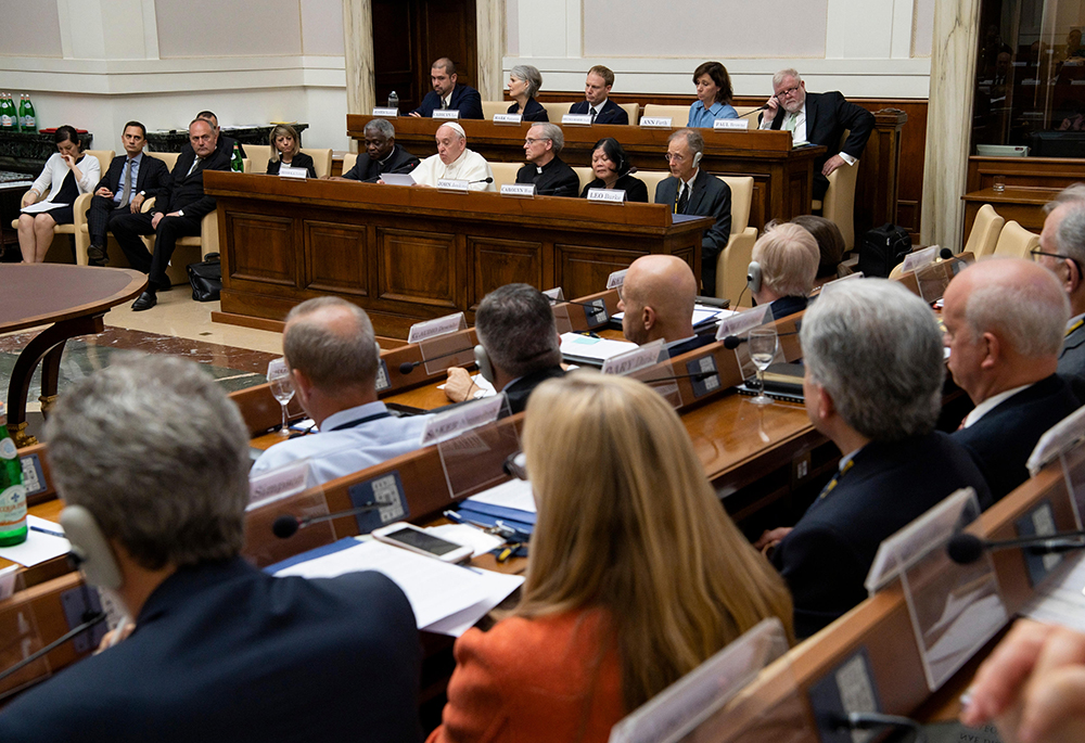 Pope Francis speaks June 14, 2019, to executives of leading energy companies meeting at the Vatican to discuss mitigating the effects of climate change. The pope is seated between Cardinal Peter Turkson, then-president of the Dicastery for Promoting Integral Human Development, and Holy Cross Fr. John Jenkins, president of the University of Notre Dame, co-sponsors of the meeting. (CNS/Vatican Media)
