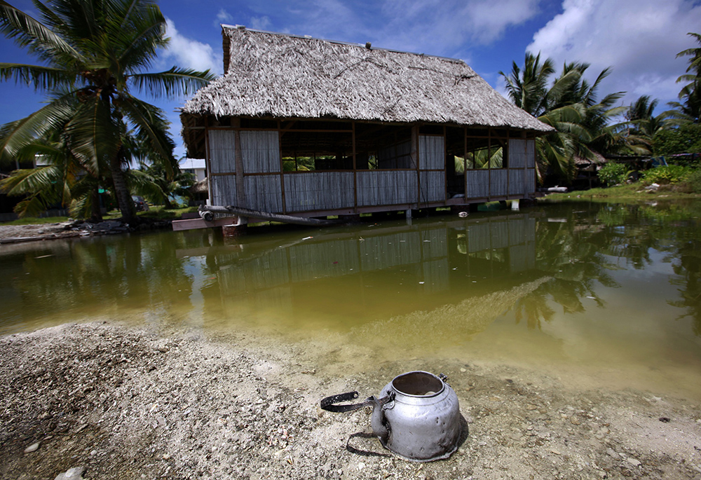 An abandoned house that is affected by seawater during high tides stands next to a small lagoon near the village of Tangintebu on South Tarawa in the central Pacific island nation of Kiribati, May 25, 2013. Pope Francis has said island nations need protection from extreme environmental and climate changes. (CNS/Reuters/David Gray)