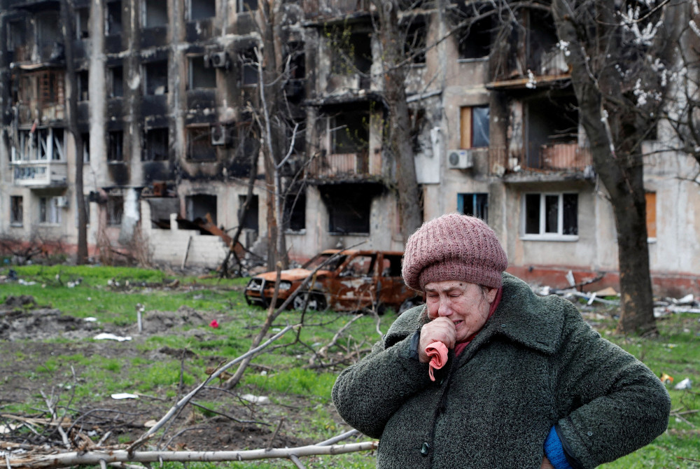 A woman cries in front of an apartment building destroyed during the Ukraine-Russia conflict in the southern port city of Mariupol, Ukraine, April 19, 2022. (OSV News/Reuters/Alexander Ermochenko)
